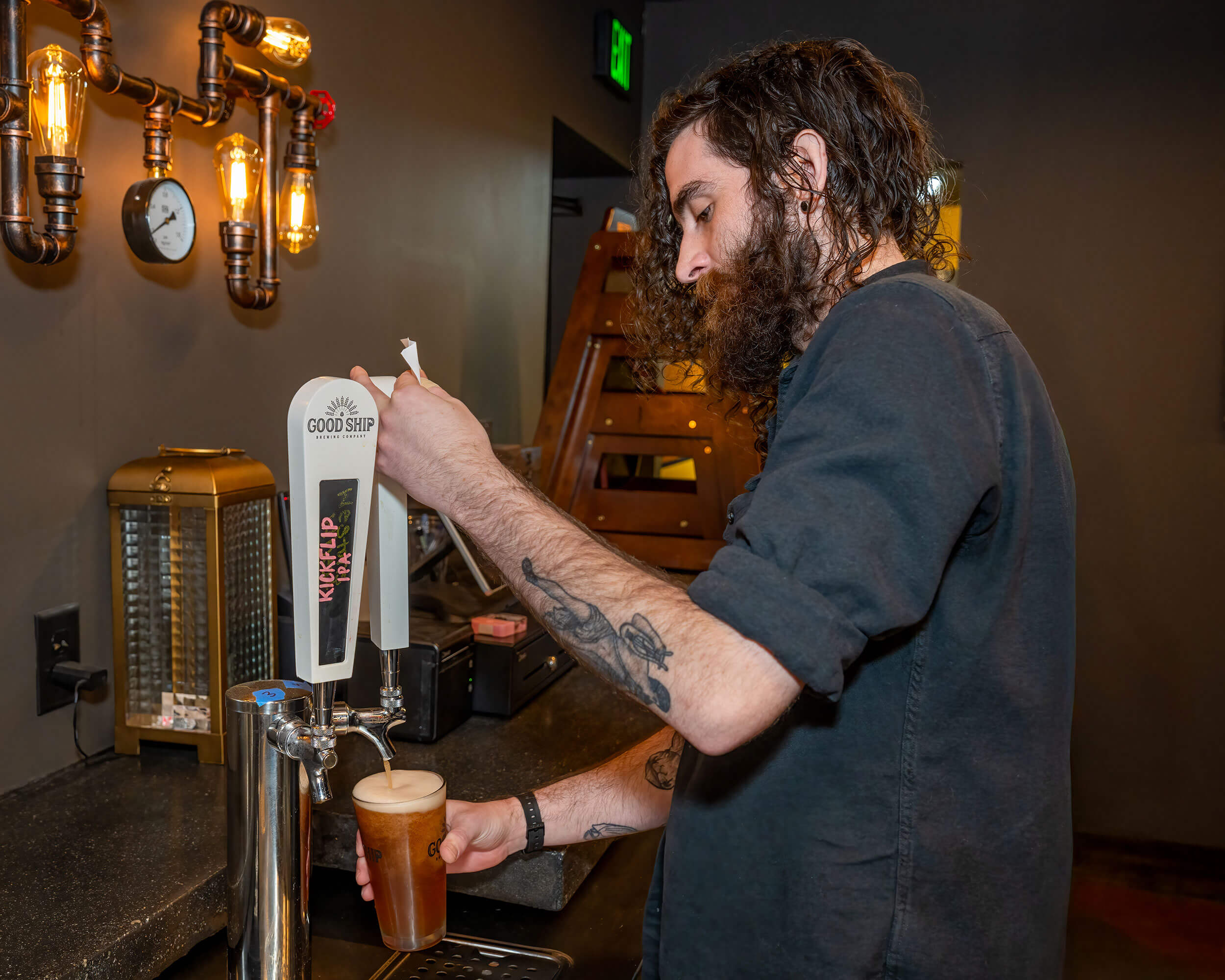 GS-Beer-Tender → Visit Hopewell / Prince George VA Man pours beer from tap into a glass at a bar, with visible foam forming at the top