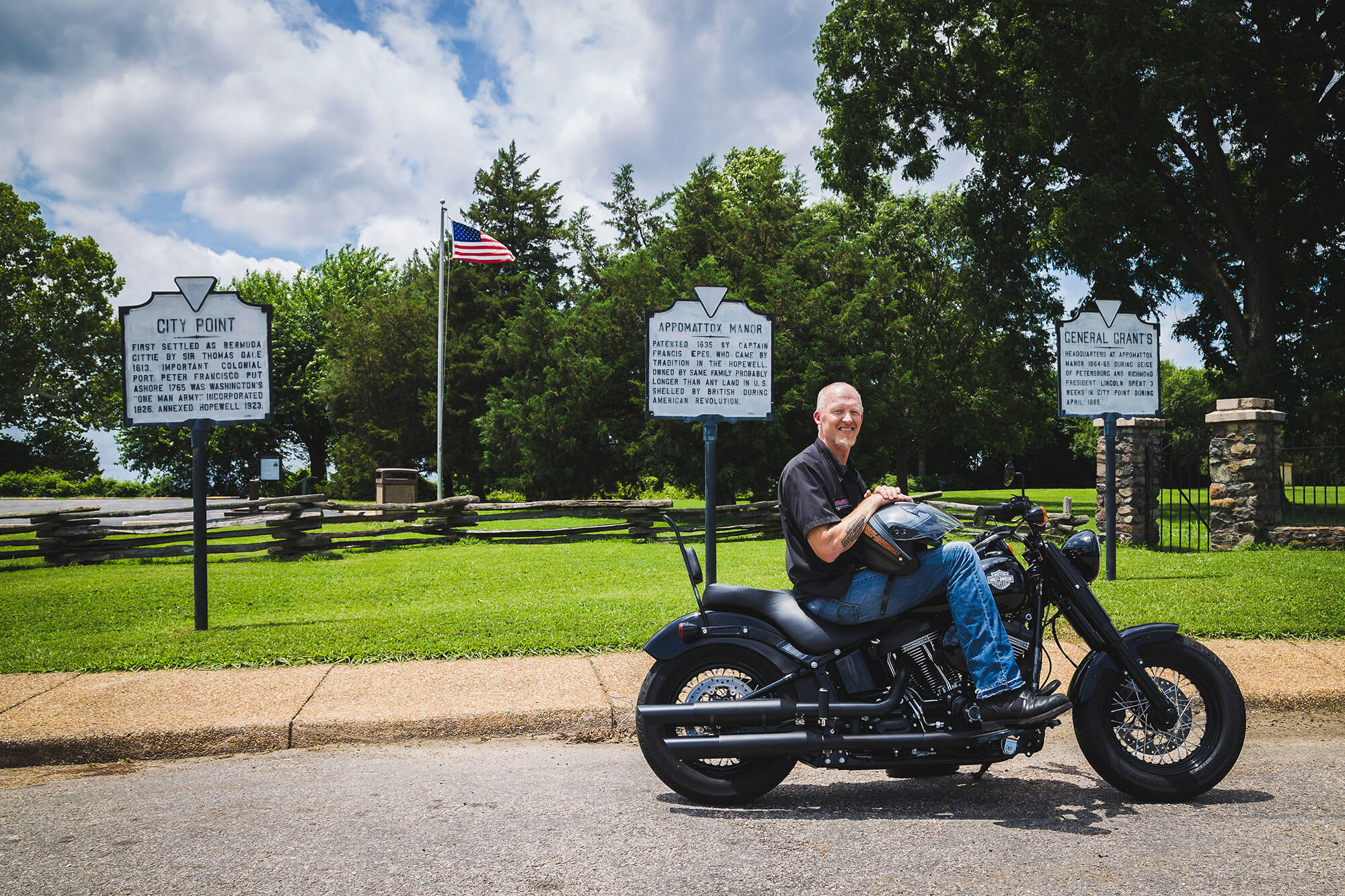 Harley-Appomattox-Manor_-2 → Visit Hopewell / Prince George VA → Visit Hopewell / Prince George VA Man on a black motorcycle beside three historical marker signs and an American flag at City Point.