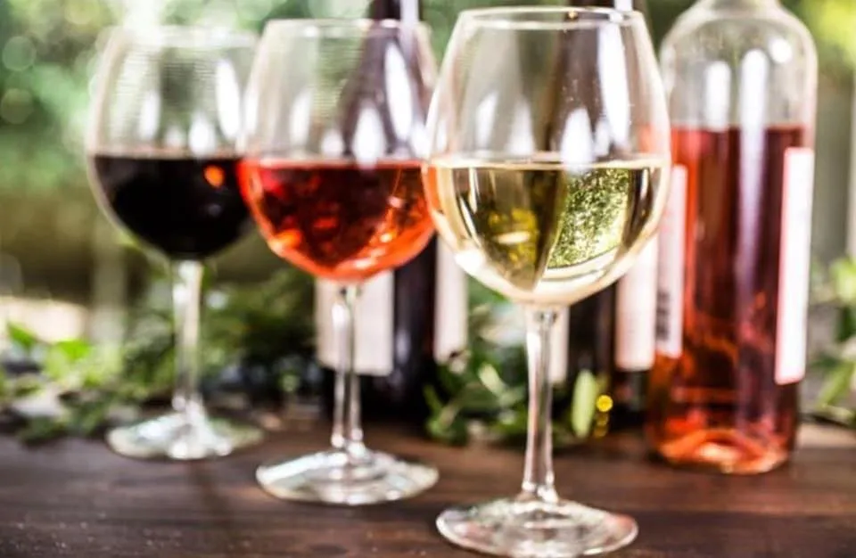 three wine glasses, from left to right, red wine, rose wine, and white wine